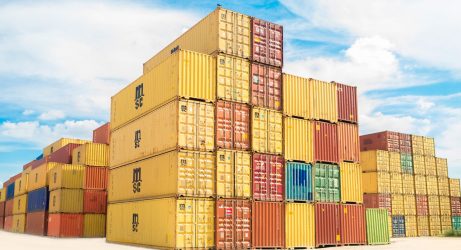 Stockfoto: Container unter einem blauen Himmel mit vereinzelten Wolken.